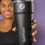 Smiling lady holding a splitflask tumbler in focus