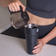 Lady pouring hot coffee into a splitflask tumbler