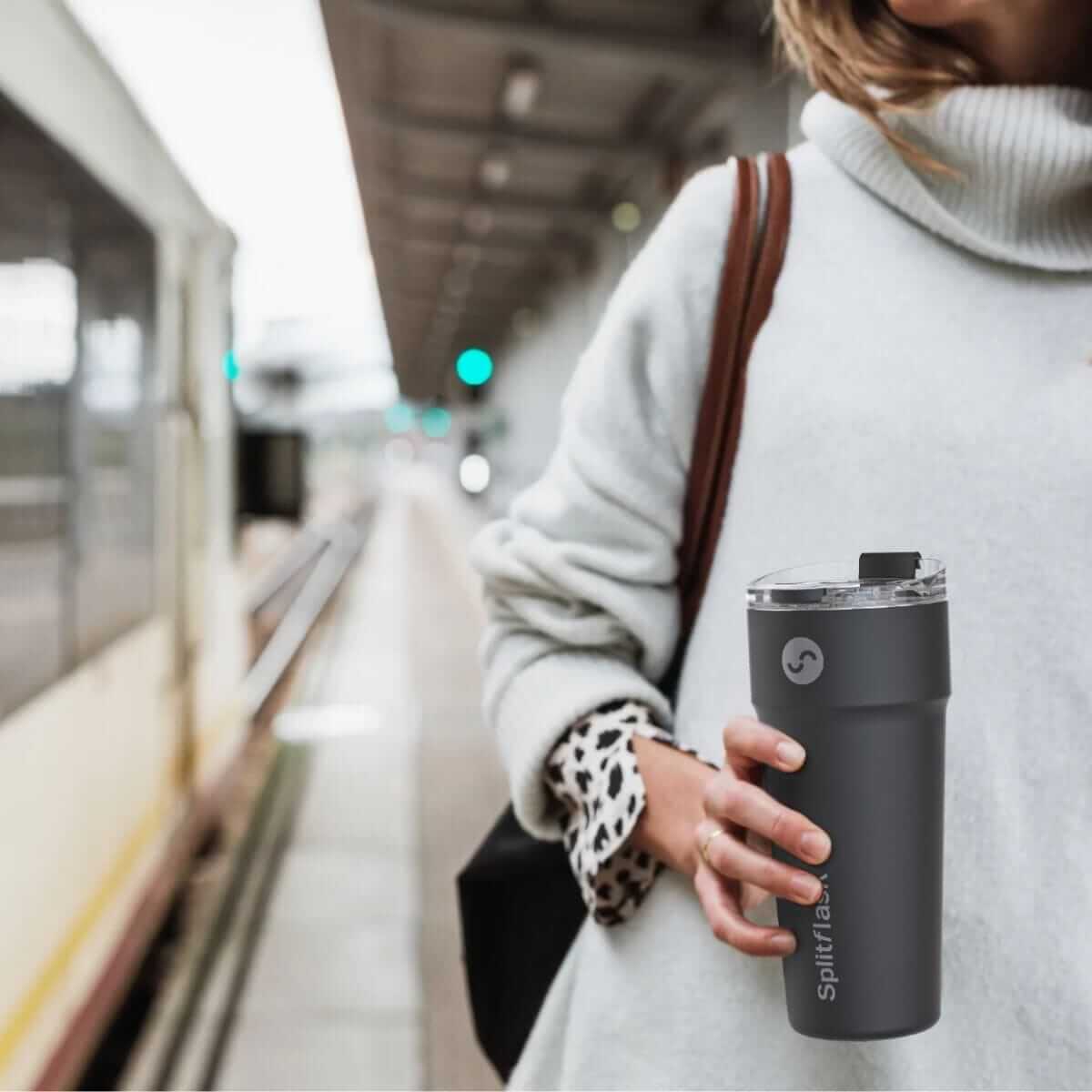 Woman at a train station holding a Splitflask tumbler on her way to work